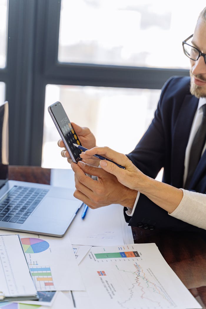 Man in Black Suit Holding a Black Smartphone